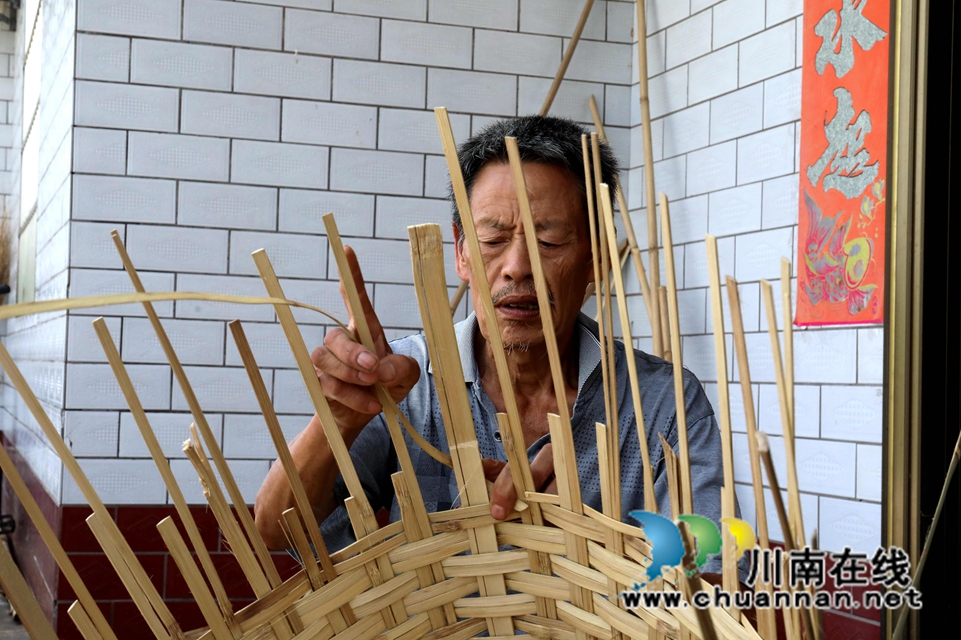 2范明青正在编制传统农具“箩蔸” 胡晓霞摄.JPG