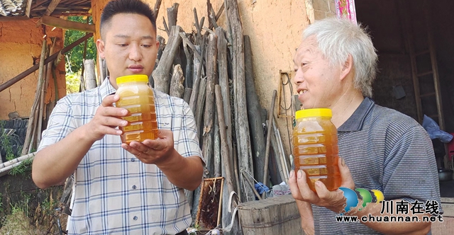 图2：王林（左）查看王殿均的蜂蜜.jpg