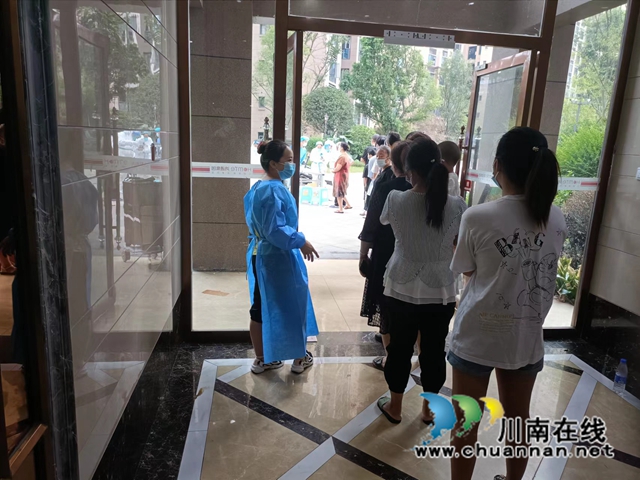 龙马潭区鱼塘街道:“大疫忘亲”的社区干部徐邱兰(图2) 徐邱兰在组织居民有序排队参与核酸检测.jpg