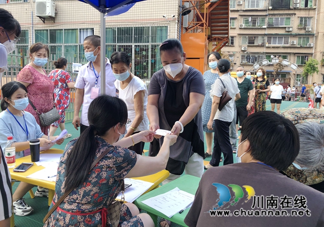 王文莲正在发放小区居民出入卡.jpg