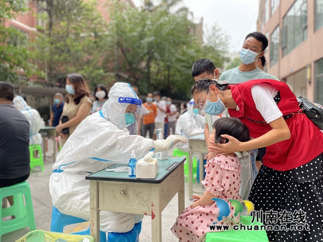 泸县:3000多名青年志愿者奋战在抗疫一线(图5) 志愿者简国勤(穿红马甲)在辅助孩子做核酸.jpg