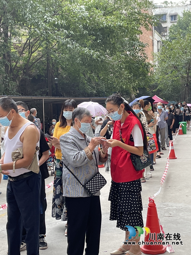 泸县:3000多名青年志愿者奋战在抗疫一线(图3) 志愿者简国勤(穿红马甲)帮助老人做核酸.jpg