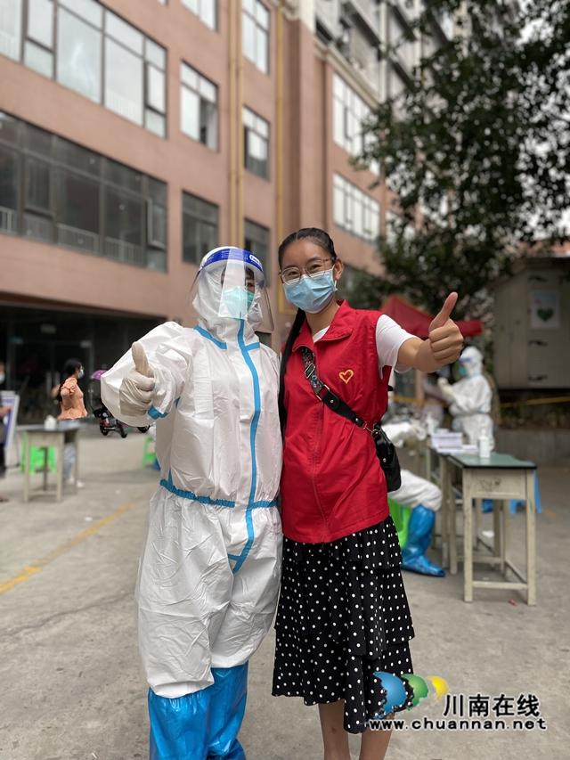 泸县:3000多名青年志愿者奋战在抗疫一线(图4) 志愿者简国勤(穿红马甲)与核酸检测人员合影.jpg