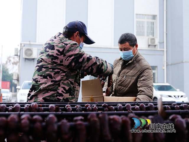 工作人员为居民打包熏制好的腊肉.JPG