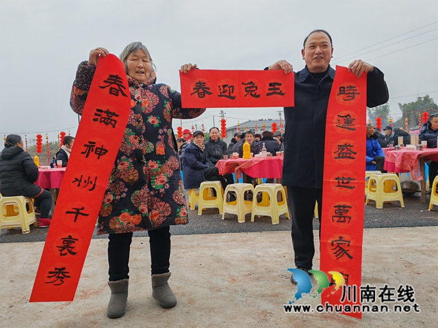泸县:200多名灾民在新村吃团圆钣(图4) 村民郭德全展示春联(曾佐然摄).jpg