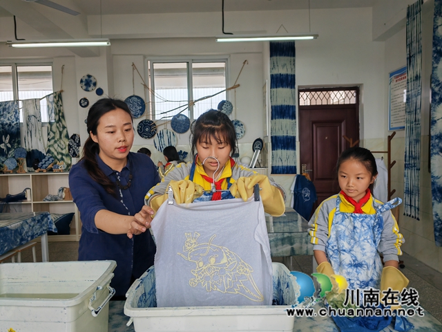 泸县:非遗“扎染”进课堂,双减落地课后服务增“色”(图8) 指导学生染色(曾佐然摄).jpg