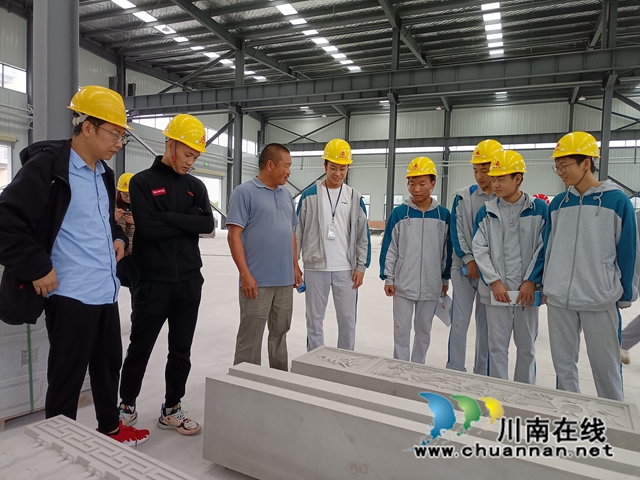 四川龙城雕塑有限公司负责人李明江（左三）向参加活动的师生代表介绍石雕文化.jpg