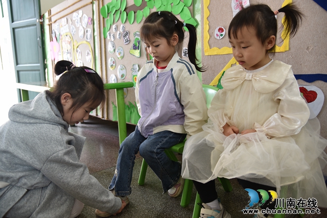 6.大班幼儿帮助小班幼儿穿鞋.JPG