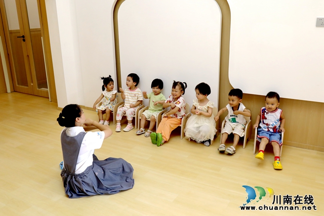 托育园内孩子们正和保育师一起做游戏1-谢汶萍摄.JPG