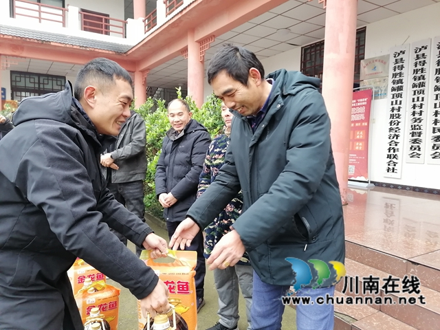 泸县农民工服务中心副主任（左一）为返乡农民工代表送上暖心慰问物品.jpg