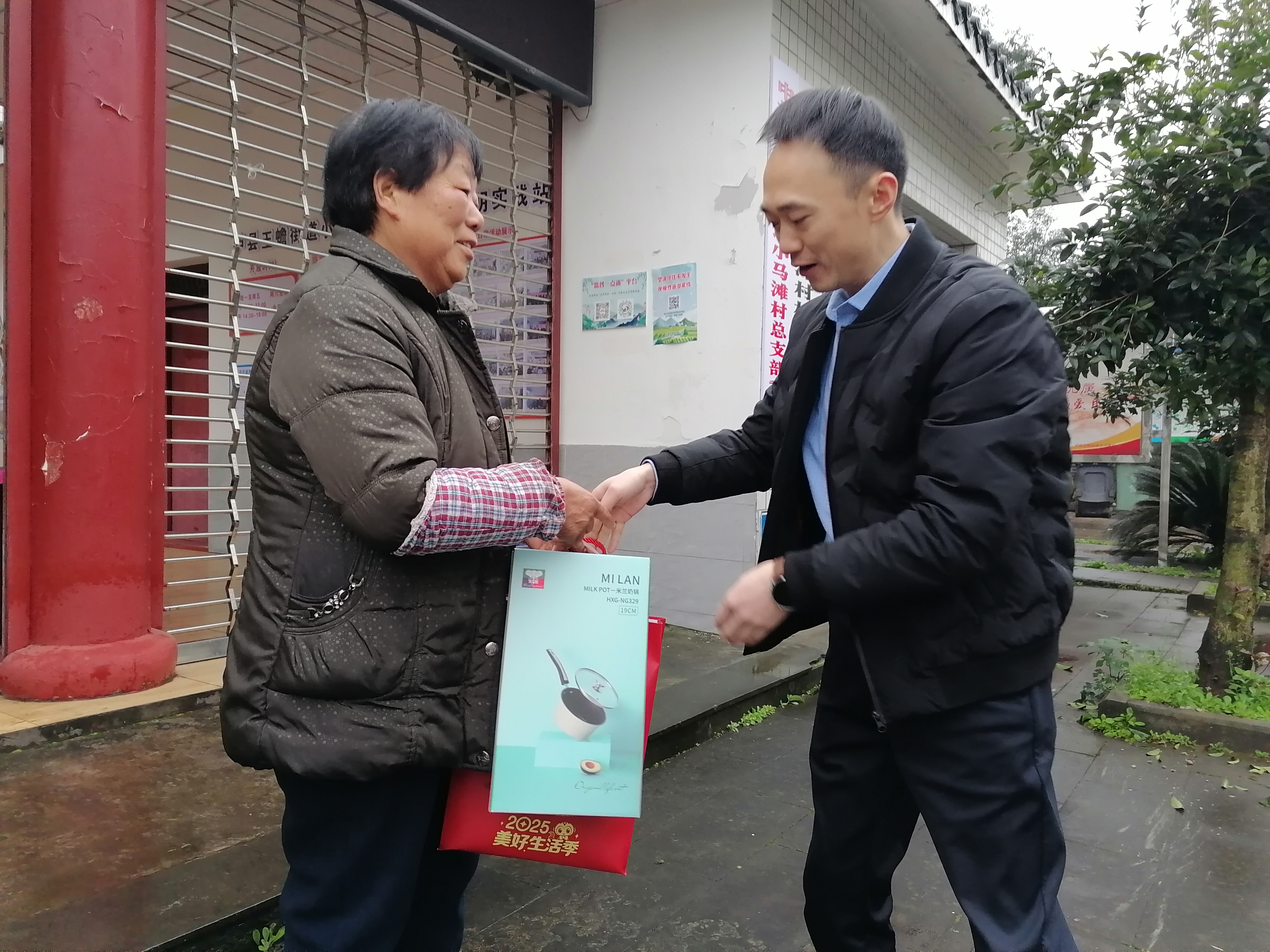邮储银行泸县支行行长陈强在泸县玉蟾街道小马滩村为农民工留守家人代表送上暖心慰问物品.jpeg