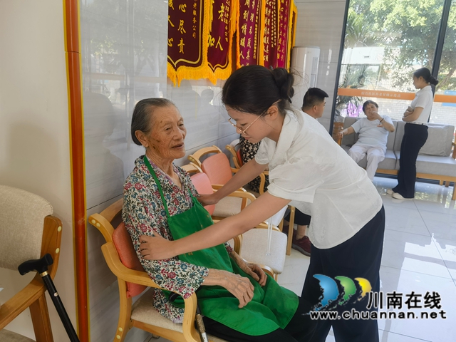 志愿者为老人们整理衣襟（龙洪艳摄）.jpg