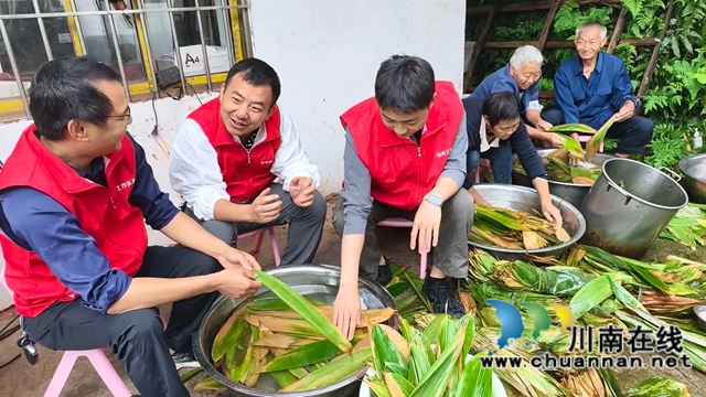 图1：王韬（左二）与驻村工作队员一起体验集体包粽子 周超文摄.jpg