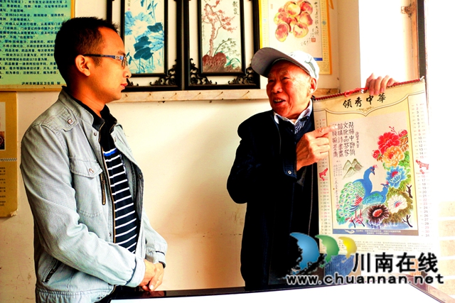 图4：李安良（右）将画作印成挂历赠友人.JPG