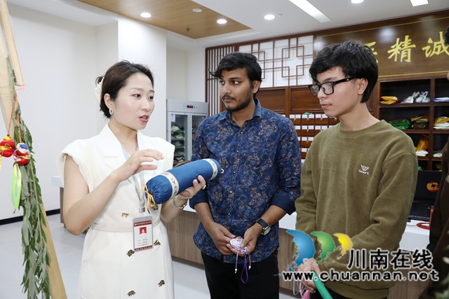 来自西南医科大学的印度留学生在听取工作人员讲解艾草枕的功效.JPG