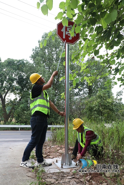 路旁工人们配合默契，正加紧安装道路安全标牌，为全线通车做最后收尾。 (2) (2).JPG