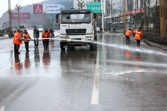 环卫洒水车为古蔺县城街道“洗澡”(图1)