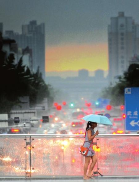 7月4日,成都春熙路人行天桥,打雨伞的行人匆匆而行。当日,成都市区出现雷雨天气。 刘陈平摄 7月4日,成都春熙路人行天桥,打雨伞的行人匆匆而行。当日,成都市区出现雷雨天气。 刘陈平摄