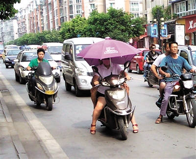 内江：电动车撑伞防晒遮雨&nbsp;交警提醒安全隐患大(图1)