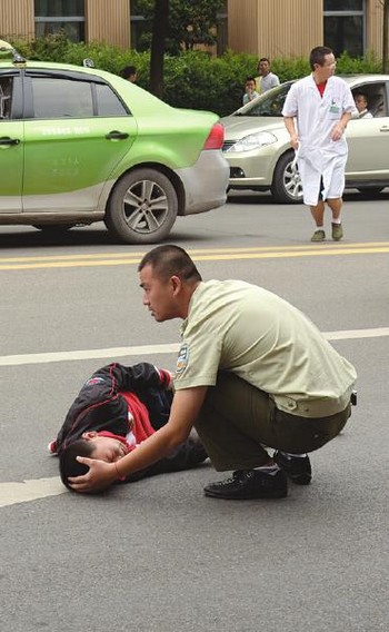 自贡:娃娃过马路被车撞倒&nbsp;城管蹲地陪他等医生(图1)