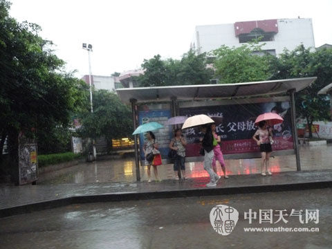 自贡普降大到暴雨 双溪水库净增蓄水120万方(图1) 雨中等待公交车的市民(袁立新 摄)