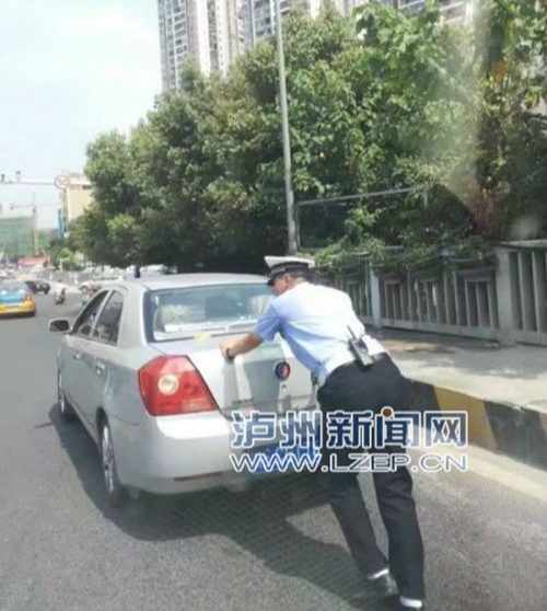 烈日下帮推车 泸州交警“正能量” 获网友点赞(图1) 烈日下帮推车 泸州交警“正能量” 获网友点赞(图1)