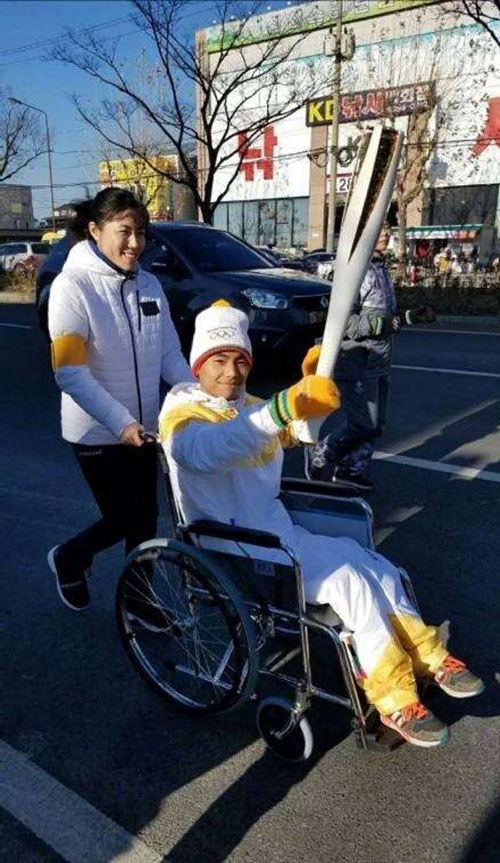 坐着轮椅传递冬奥会火炬 倒立男孩站起来了(图1) 坐着轮椅传递冬奥会火炬 倒立男孩站起来了(图1)