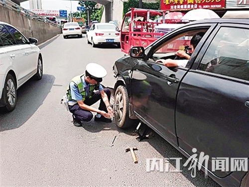 内江：汽车爆胎困路上&nbsp;交警当起“修车工”(图1)